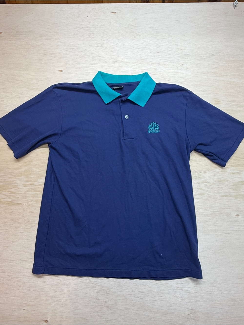 Vintage Classic Line polo shirt in navy blue with a teal collar and embroidered
